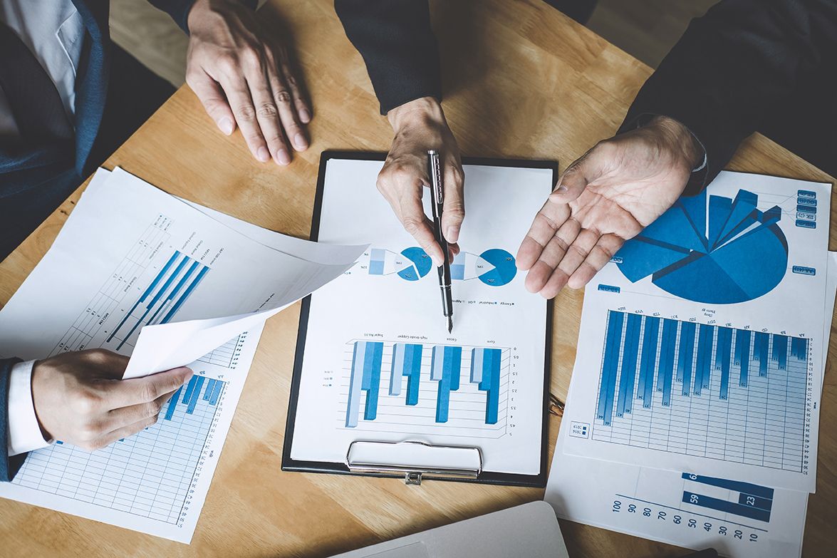 hands explaining roofing financing with graphs & charts