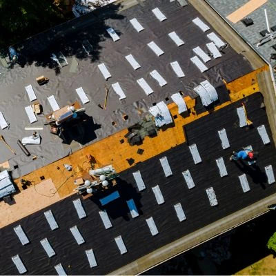 An Alan's Roofing crew installing a new roof on a commercial building.