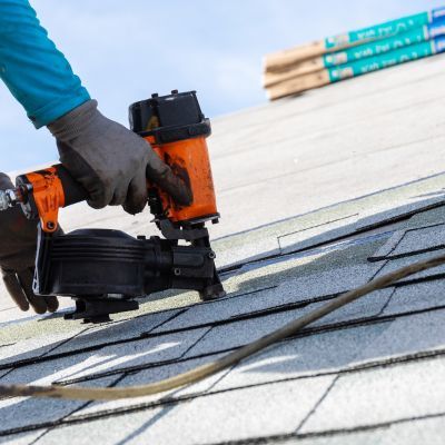 yellow nail gun being used on roof to complete repair job